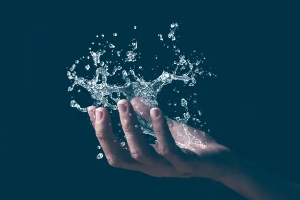 A human hand holding a graphic splash of water.