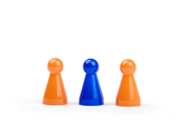 a series of orange game pieces and one different and exceptional blue figure as leader or boss - isolated on a white background - board game piece leisure games blue isolated imagens e fotografias de stock