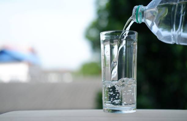 istock Pouring drinking water on wooden background 1163119537