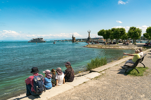 Konstanz, BW / Germany - 14. July 2019: tourists enjoy a beautiful summer day on the shores of Lake Constance with ships passing by