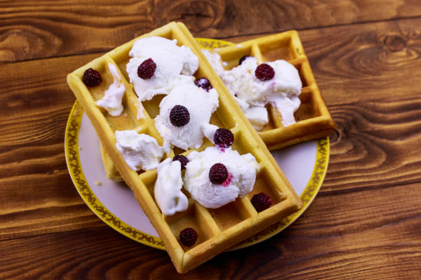 istock Belgian waffles with ice cream and blackberries on wooden table 1163121299