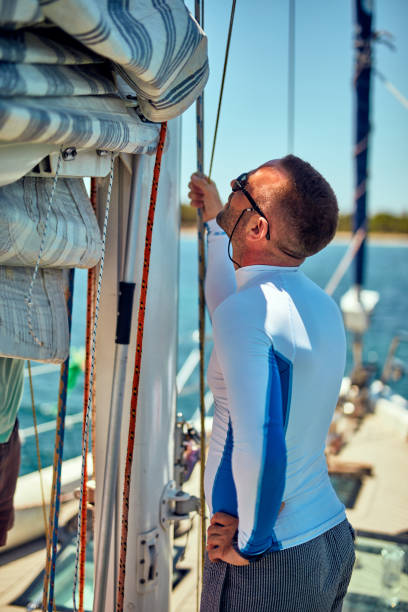 istock Sailor packing / unpacking main sail wing on the boat. 1163123903