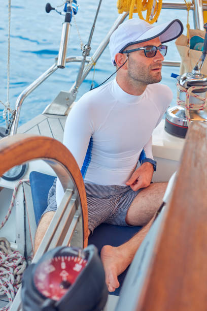 istock Sailor using wheel to steer rudder on a sailing boat. 1163124149