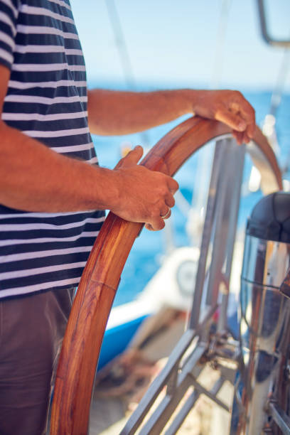 istock Sailor using wheel to steer rudder on a sailing boat. 1163124167