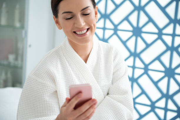 istock Happy lady with mobile phone in spa center 1163126378