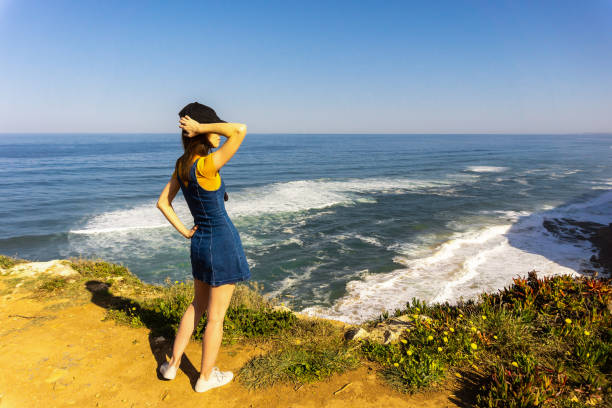 istock Young woman from back looking to Azenhas do Mar, located on the cliffs 1163127556