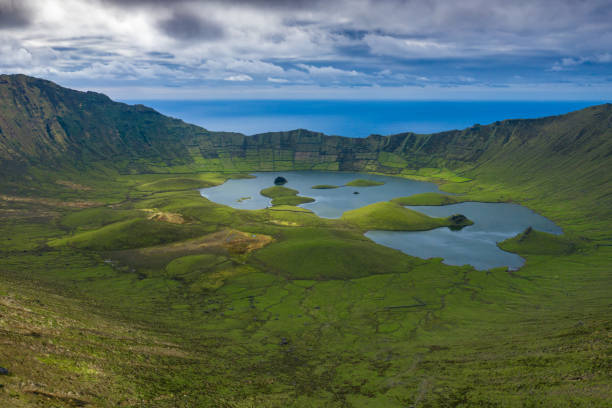 Aerial view of volcanic crater (Caldeirao) with a beautiful lake on the top of Corvo island. Azores islands, Portugal. stock photo