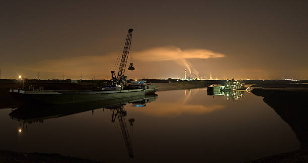 A dredger and industry with clean reflection. Panoramic shot in Duisburg, Germany.
