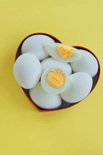 istock Healthy eating - eggs in heart shaped box on yellow background 1163137352