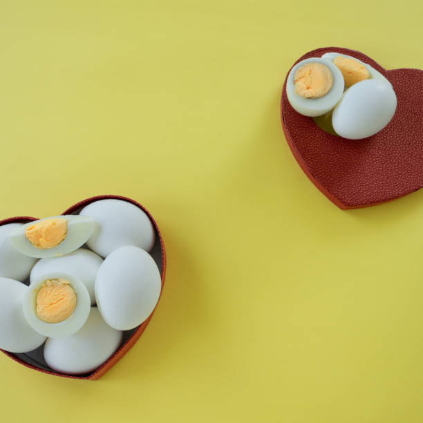 istock Healthy eating - eggs in heart shaped box on yellow background 1163137356