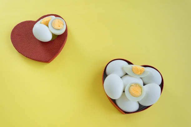 istock Healthy eating - eggs in heart shaped box on yellow background 1163137357