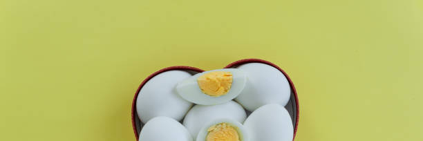 istock Healthy eating - eggs in heart shaped box on yellow background 1163138004