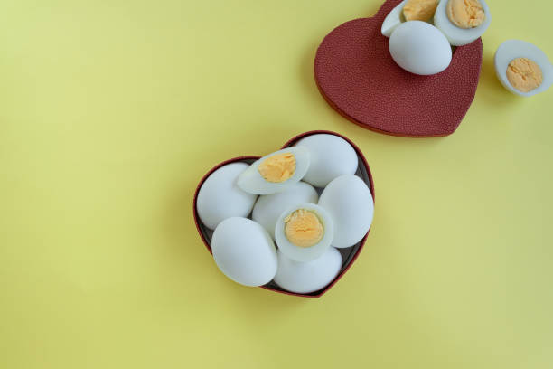 istock Healthy eating - eggs in heart shaped box on yellow background 1163138557