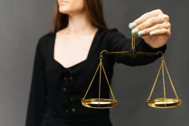 istock Serious woman holding the justice scale on dark background 1163139039