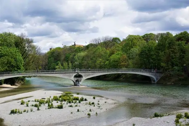 The Kabelsteg bridge in Munich, Germany over the river Isar with the Maximilianeum in the background