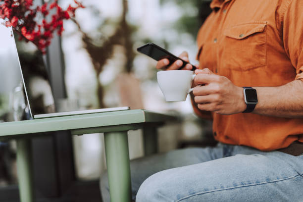 istock Young man enjoying coffee and using cellphone in outdoor cafe 1163144292
