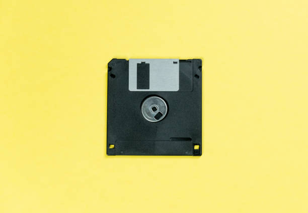 istock black floppy disk on yellow background. retro magnetic storage 1163145598