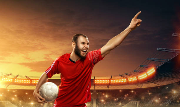 istock Soccer player celebrates victory on a floodlit night stadium 1163147237