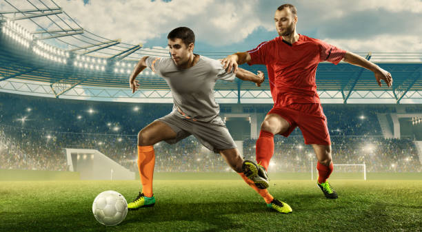 два исповедальных футболиста борются за мяч на стадионе - kick off soccer player soccer kicking стоковые фото и изображения