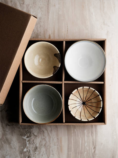 пустая керамическая чаша, стек тарелок и чаш в картонной коробке,чаша фарфора в картонной коробке,пустая керамическая плита, - blue bowl brown ceramic стоковые фото и изображения