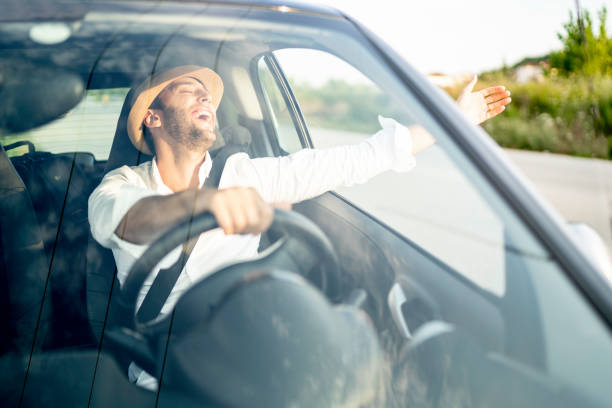 istock Happy man driving and celebrating with arm open 1163152343