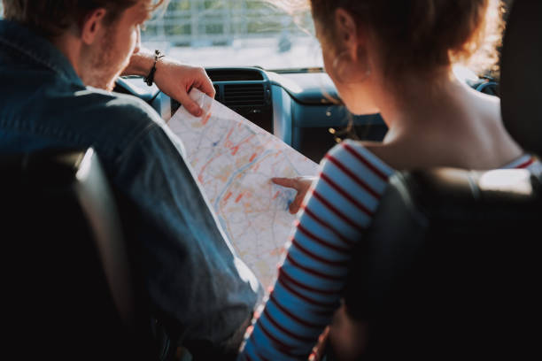 istock Young couple reading city map in the car 1163152777