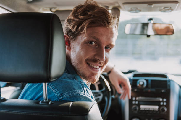 istock Handsome young man sitting in his car 1163152778
