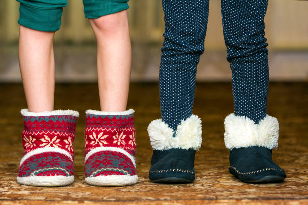 istock Bare child legs and feet in red winter christmas boots with ornament pattern 1163153448