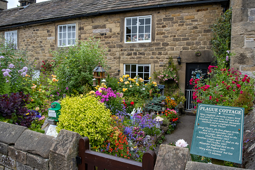 Eyam, United Kingdom - July 11th, 2019: In 1665 residents of these cottages succumbed to the Bubonic Plague outbreak in the Peak District village of Eyam in Derbyshire, UK. The Bubonic plague ran its course over 14 months and one account states that it killed at least 260 villagers, with only 83 surviving out of a population of 350.