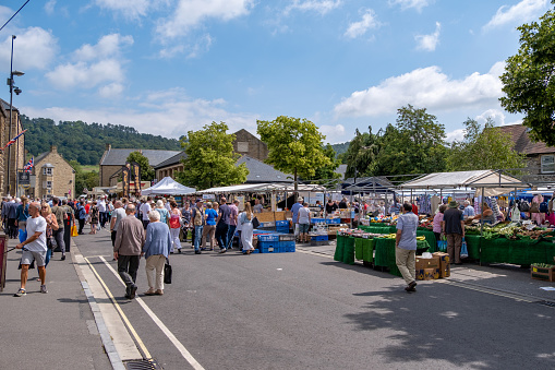 Bakewell, Derbyshire, United Kingdom - July 15th, 2019 : The twice weekly street market.  Bakewell is a small market town and civil parish in the Derbyshire Dales district of Derbyshire, England, well known for the local confection Bakewell pudding. It is located on the River Wye, about thirteen miles southwest of Sheffield.