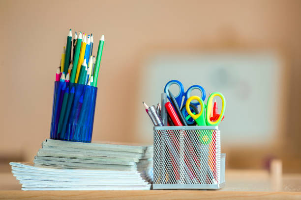 istock Stack of notebooks, colorful drawing pencils and stationery arrangement on copy space background. 1163155022