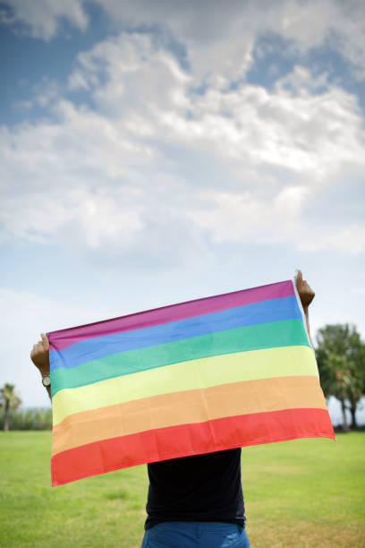 istock Gay Man Holding Rainbow Flag 1163156957