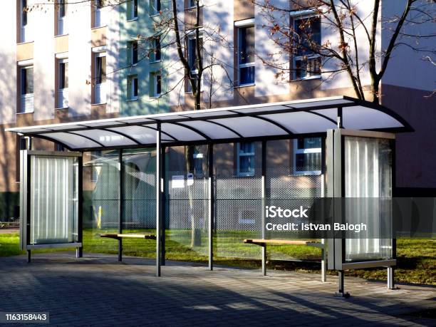 Bus Shelter At A Bus Stop Of Glass And Aluminum Structure In Park Like Setting Stock Photo - Download Image Now