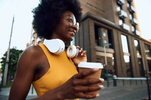 istock Joyful young lady is holding coffee outdoors 1163158793