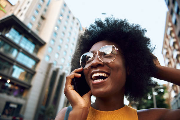 istock Smiling young woman is talking on mobile phone 1163158858