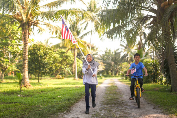 istock Kids playing with bicycle and holding Malaysia flag 1163161531