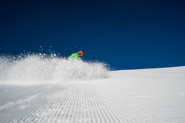 istock skier splashing snow on piste dark blue sky 1163162152