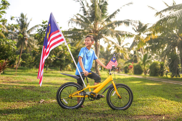 istock Kids playing with bicycle and holding Malaysia flag 1163162157