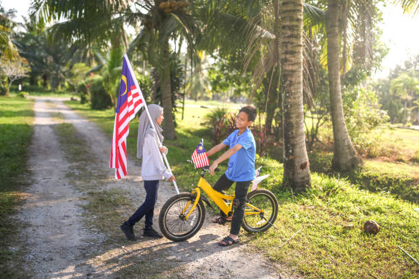 istock Kids playing with bicycle and holding Malaysia flag 1163162875