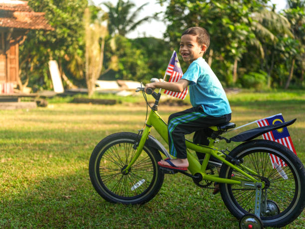 istock Cute kids cycling with national flag 1163168939