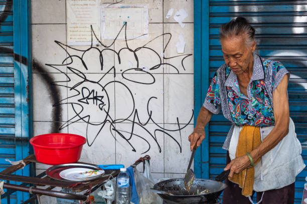 donna locale che cucina street food nel centro di bangkok - thailand thai culture thai cuisine pad thai foto e immagini stock