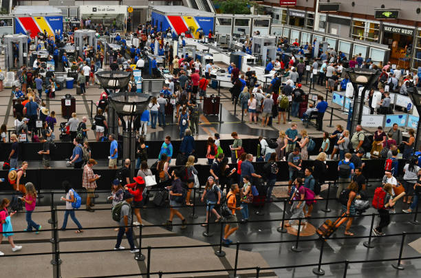 Crowds of travelers in long queue at TSA Security Check at Denver International Airport over summer holiday weekend. Crowds of travelers in long queue at TSA Security Check at Denver International Airport over summer holiday weekend. department of homeland security stock pictures, royalty-free photos & images