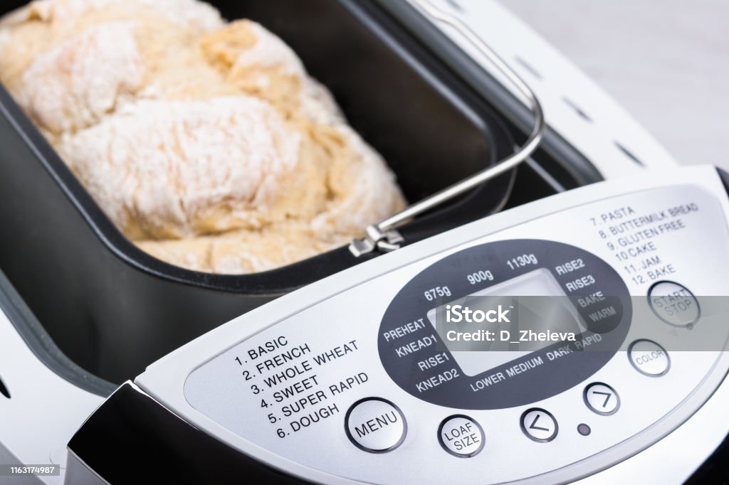 Homemade white flour bread baked in bread maker with digital display Homemade white flour bread baked in bread maker with digital display. Bread Stock Photo