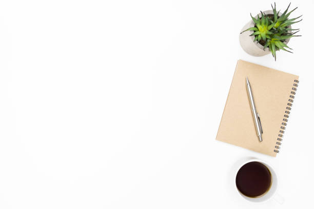 istock White minimalist office desk table with notebook, pen, cup of coffee and cactus pot. Top view with copy space, flat lay. 1163175227