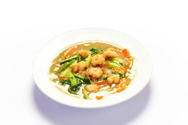 Shrimp salad with mushrooms. It is located on a white surface. Close-up.