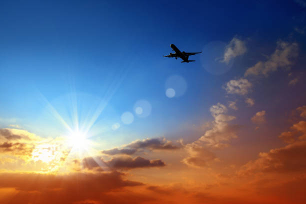 istock flying commercial passenger airplane over sunset sky 1163179671
