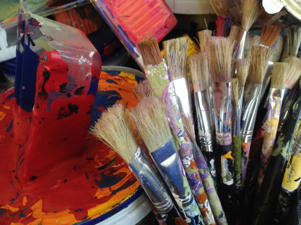 istock Paintbrushes and trays used in art that has not been cleaned. 1163180933