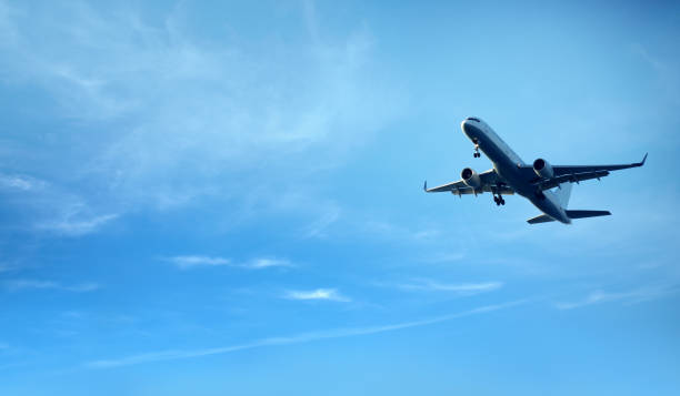 istock flying commercial passenger airplane over cloudy blue sky 1163182397