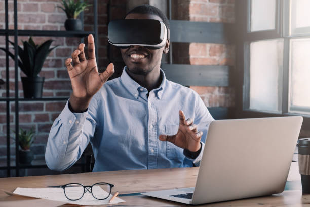 istock Portrait of young african american professional using augmented virtual reality in modern loft office. VR technology 1163183086