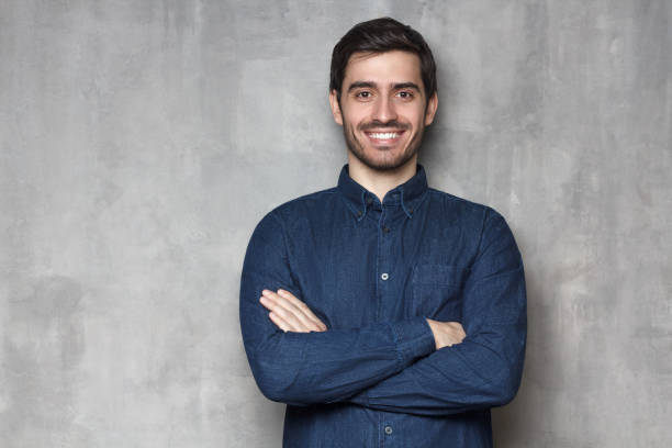 istock Positive European guy leaning on wall, smiling, isolted on background 1163183104